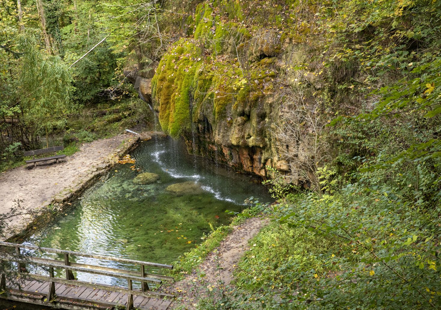 Kallektuffquell: Clear, mineral-rich water flows over a rock ledge