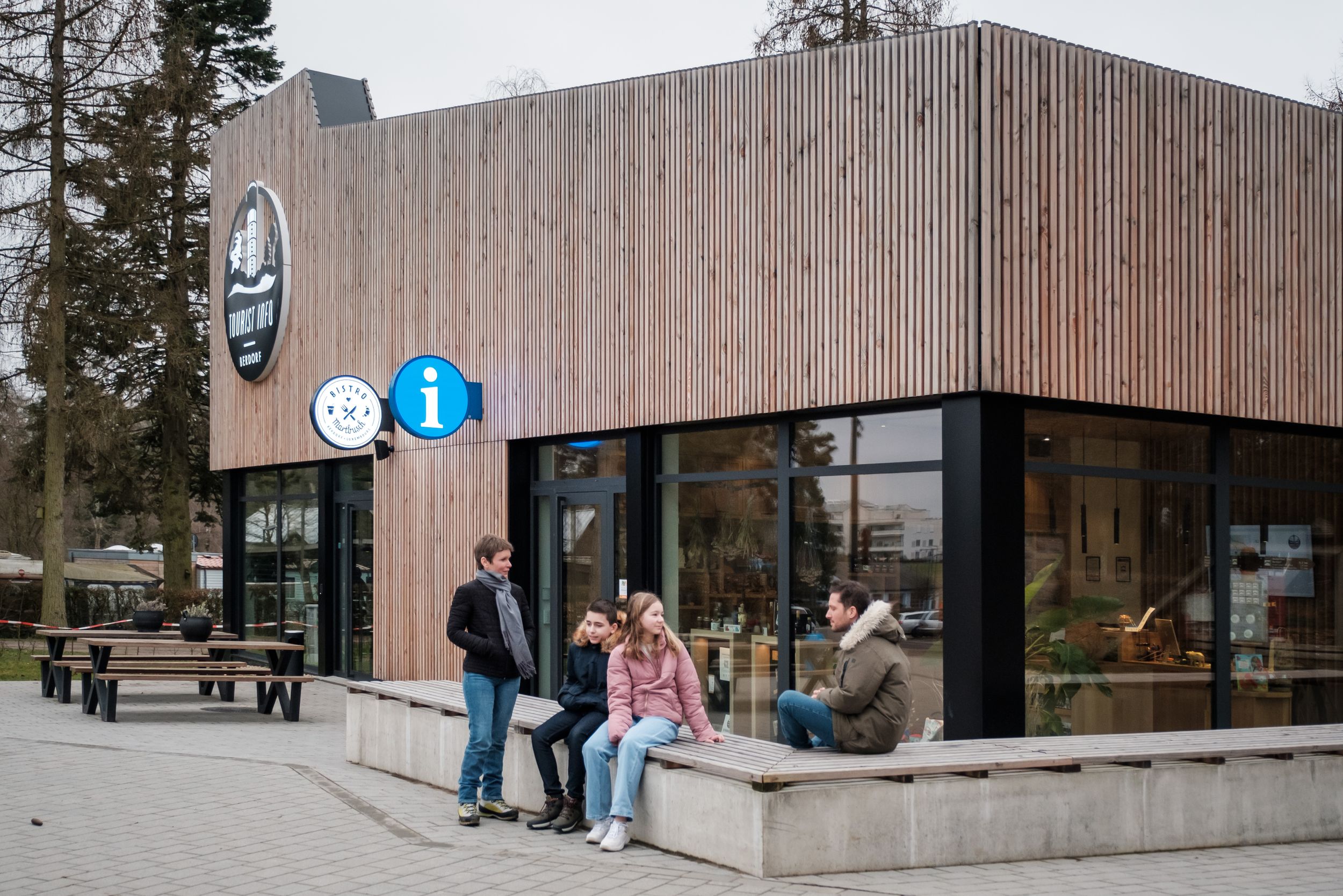 A family in front of the Tourist Office in Berdorf during winter