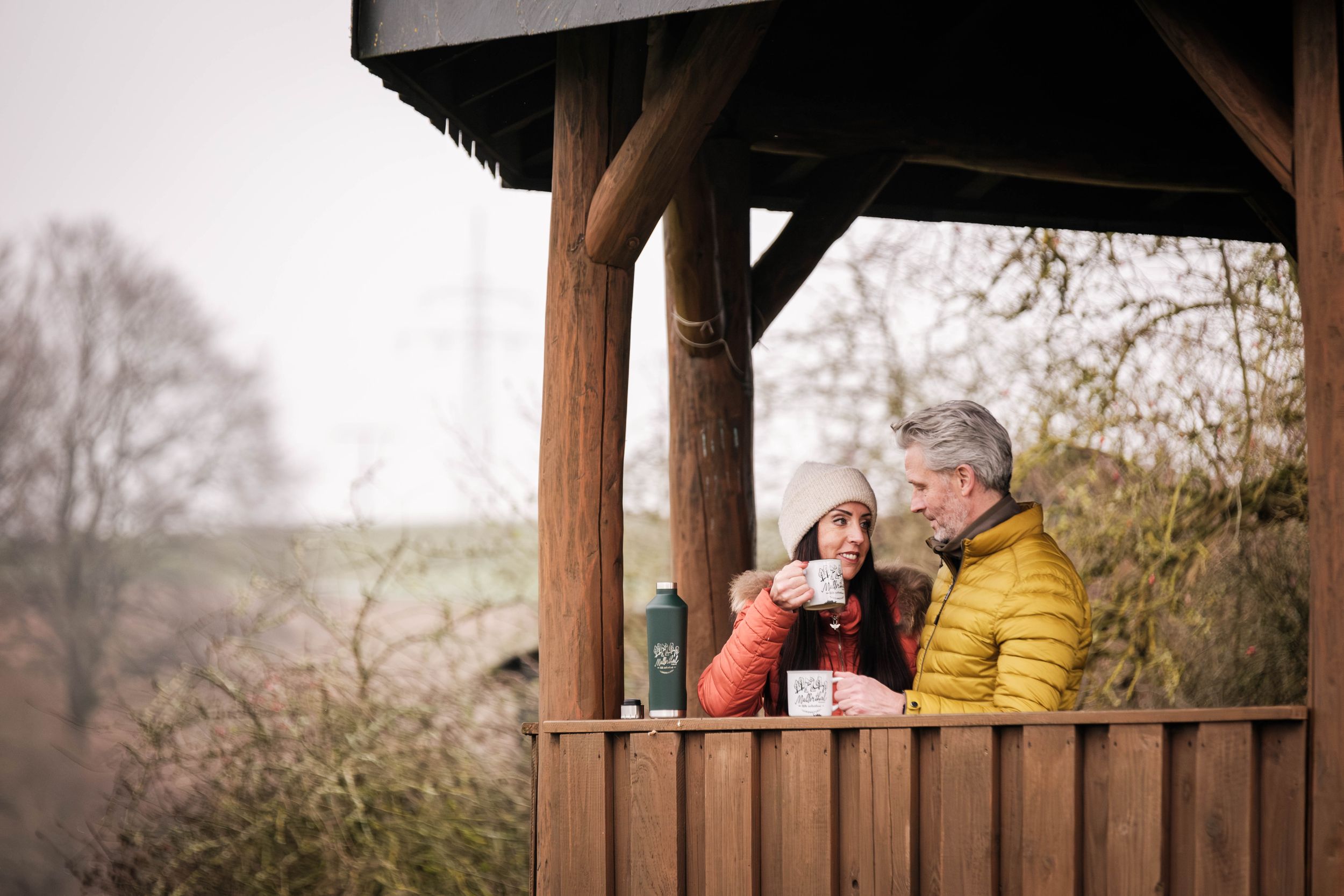 Couple drinking coffee together at a picnic spot in winter