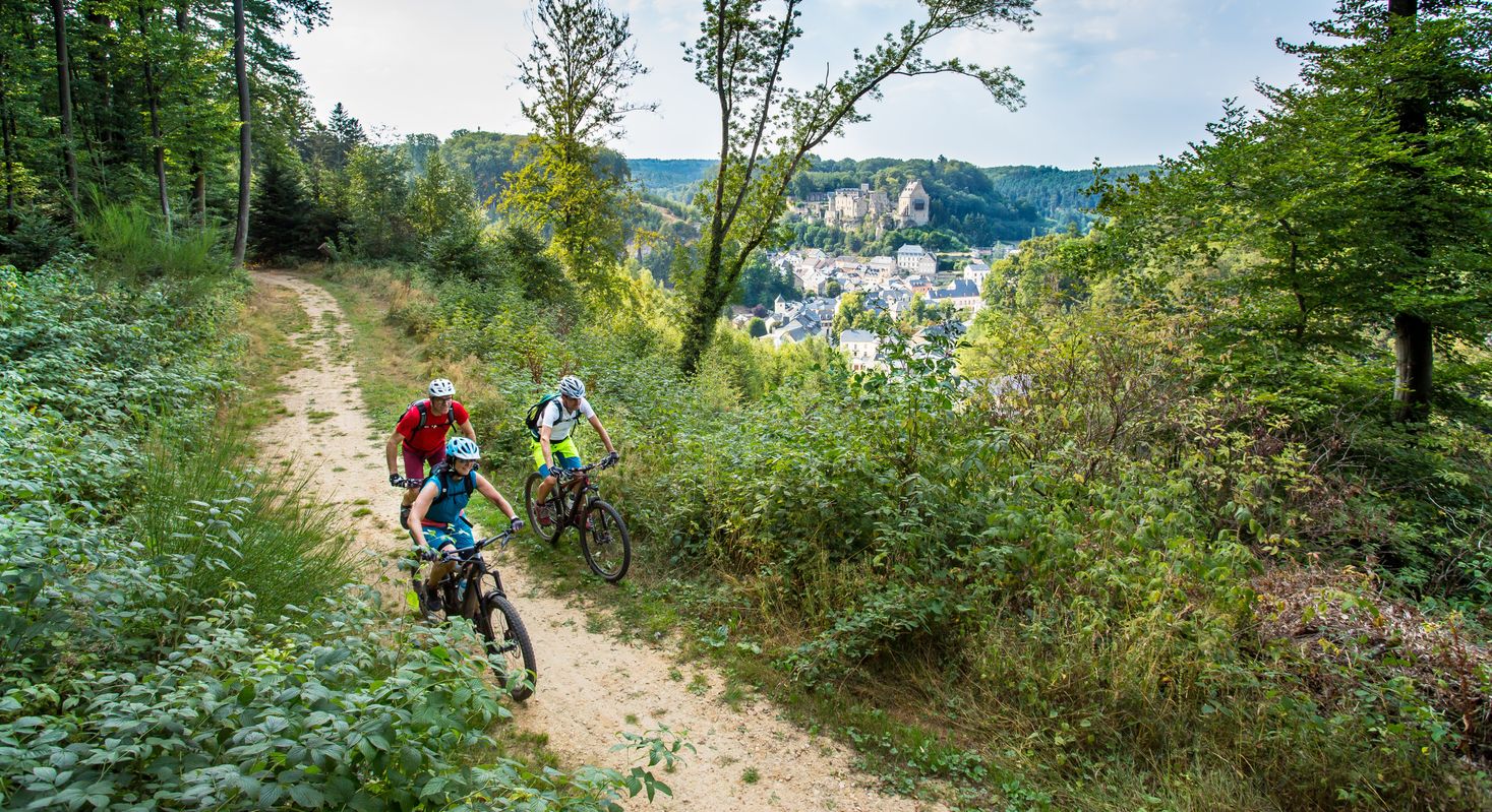 A group of mountain bikers ride through the forest of Larochette