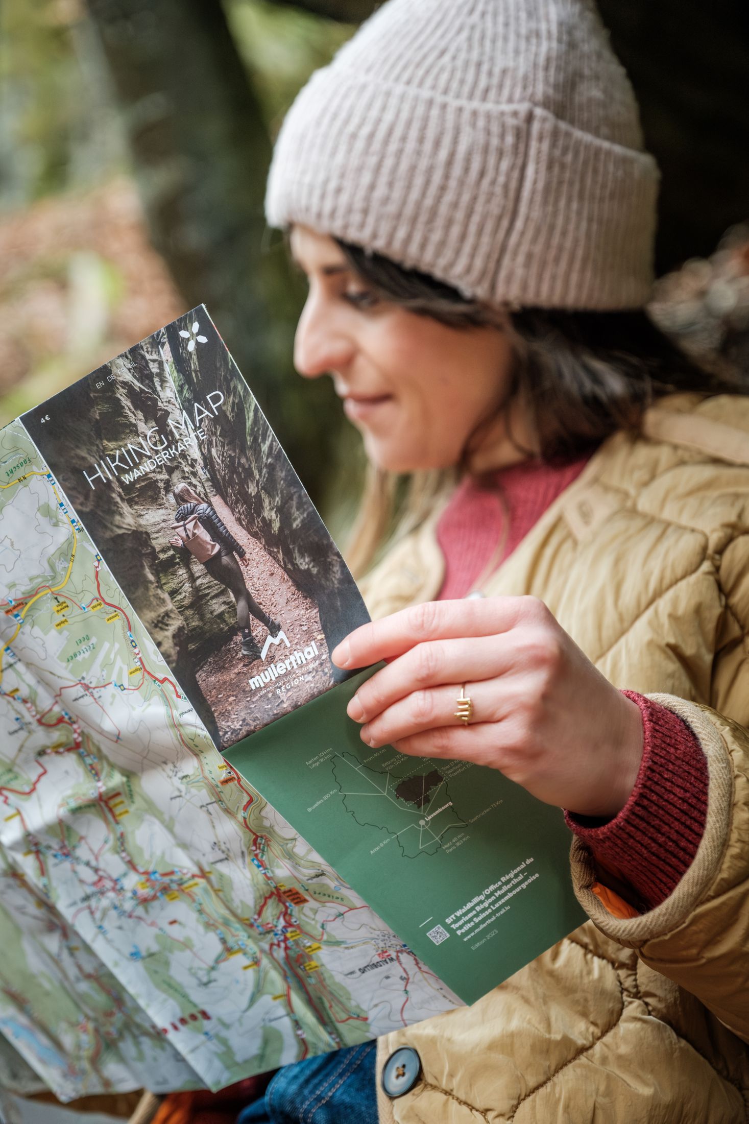 Een persoon bekijkt de wandelkaart van de Mullerthal Regio