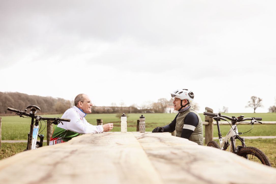 Two bikers taking a break on a bench