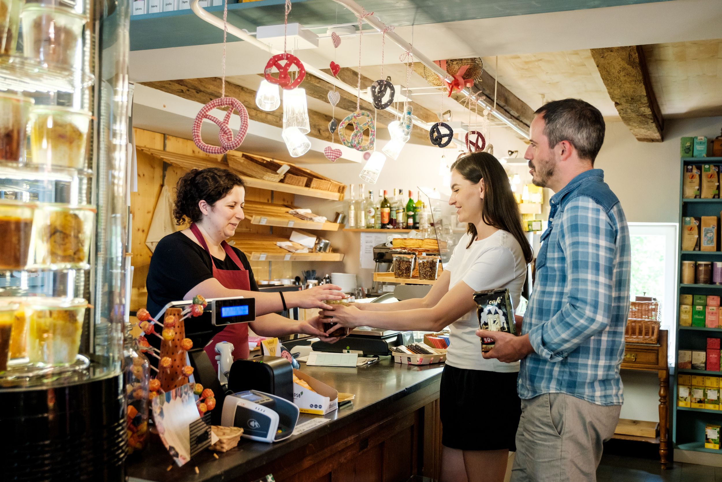 Two people buying something at „Epicerie Am Duerf“ in Schrondweiler