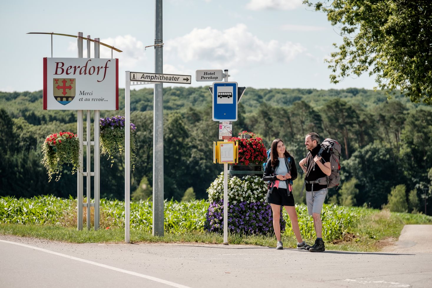 Two people waiting for the bus at the bus stop in Berdorf