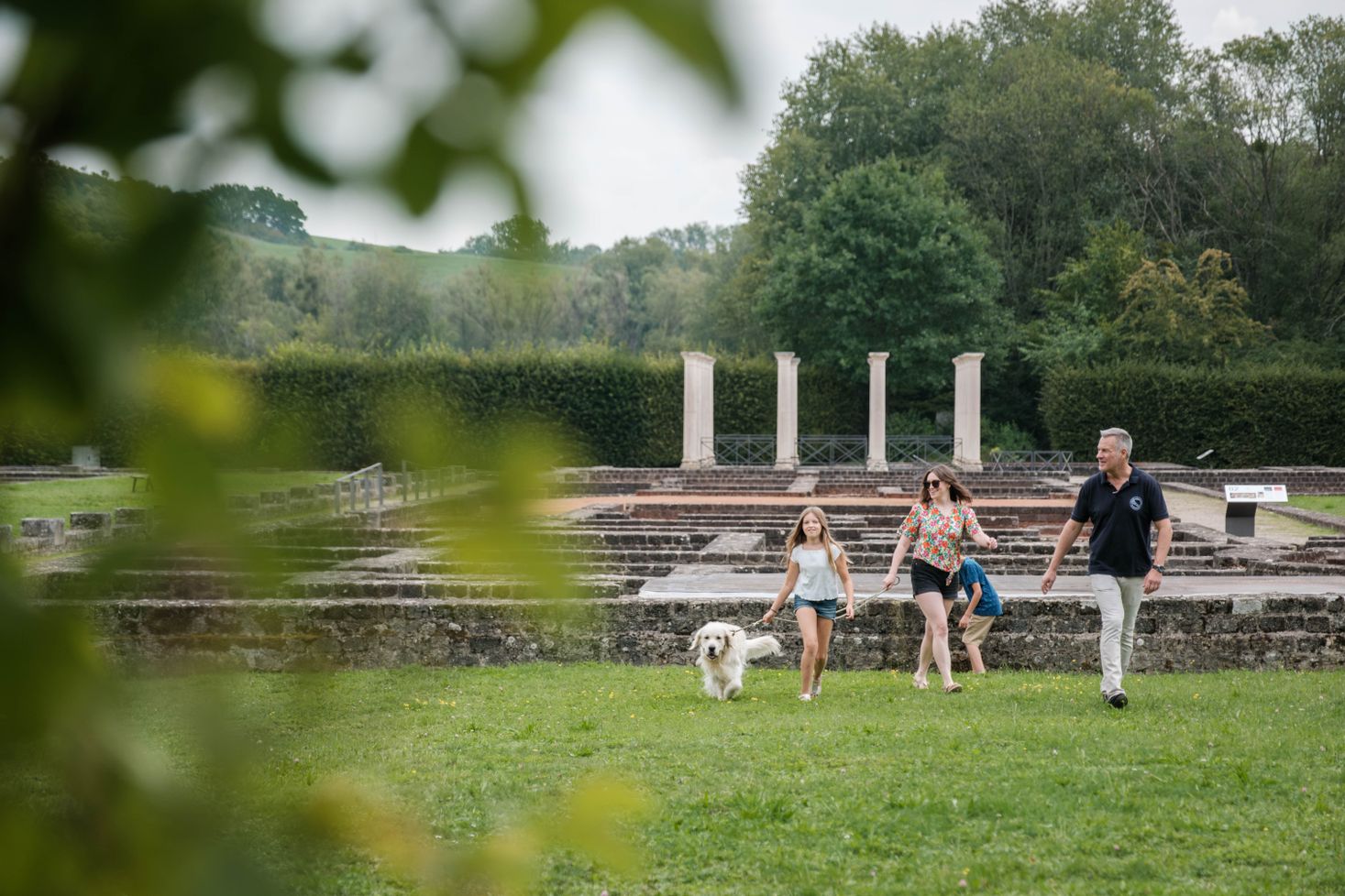 Eine Familie mit Hund vor der Römervilla in Echternach