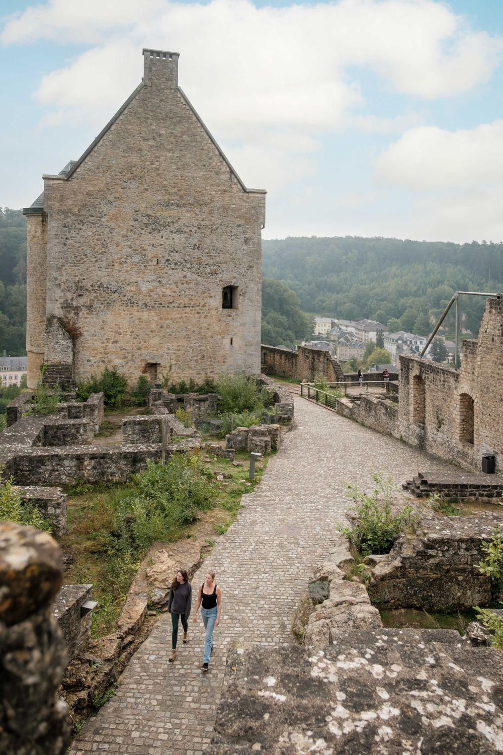 Bezoekers wandelen door de ruïnes en paden van het kasteel Larochette